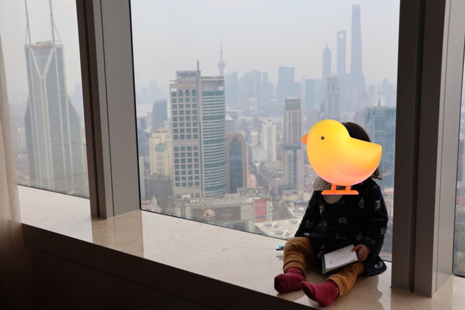 JWマリオット上海の高層階の窓際で街を眺める子ども