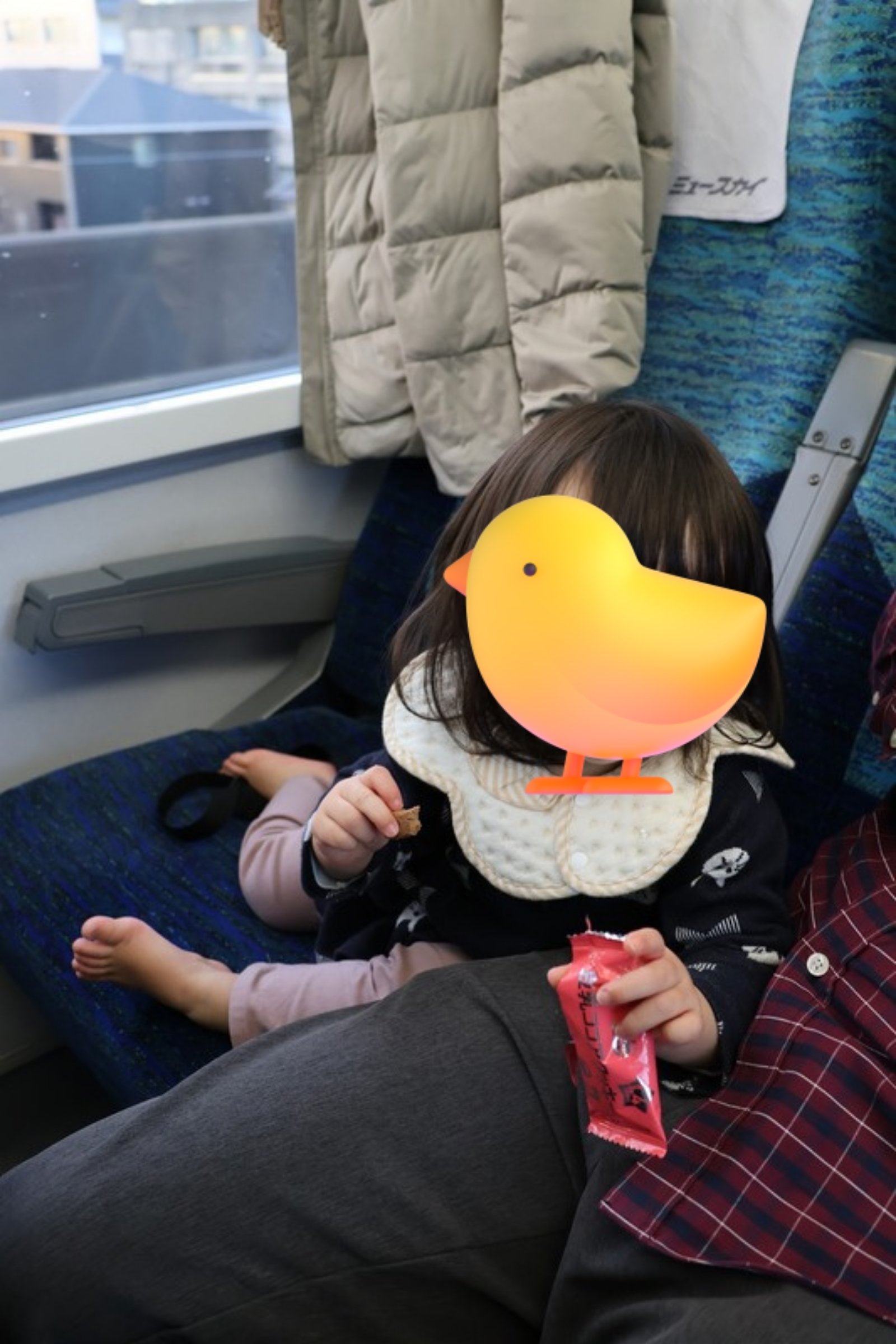 名鉄ミュースカイの車内でお菓子を持つ子ども