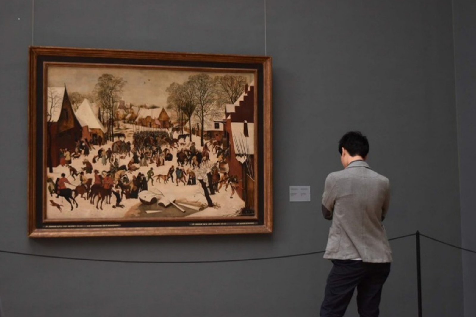 美術館で雪景色の絵画を見つめる後ろ姿