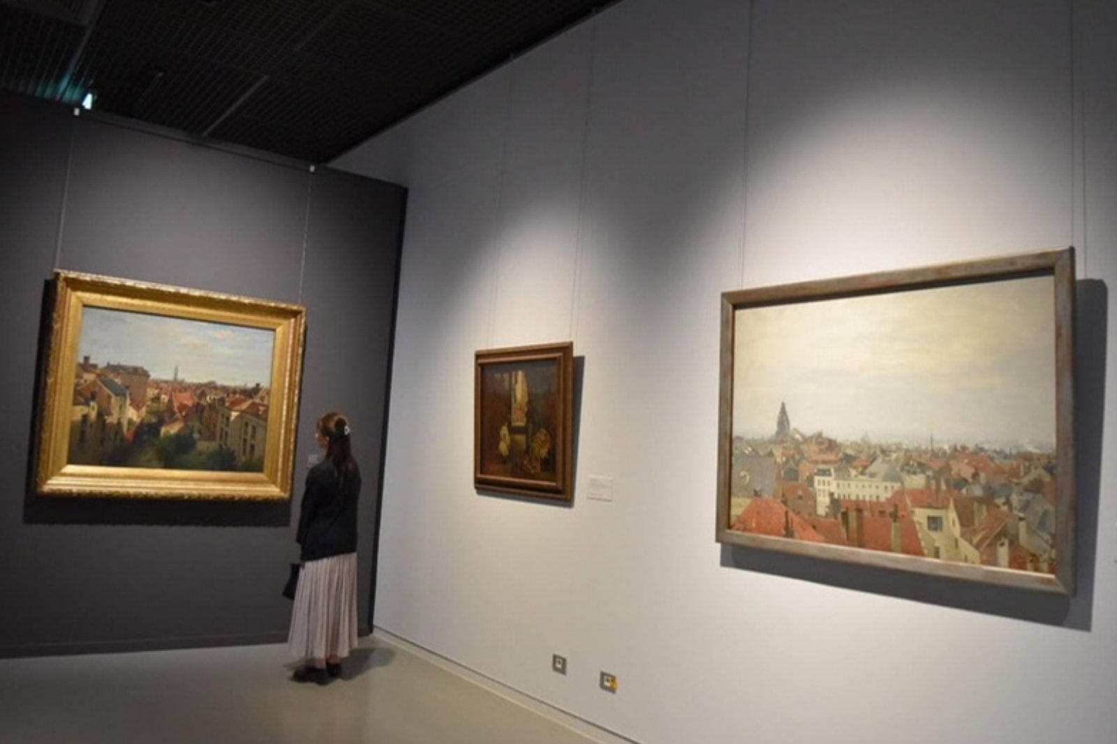 美術館で街並みの絵画を鑑賞する奥さまの後ろ姿