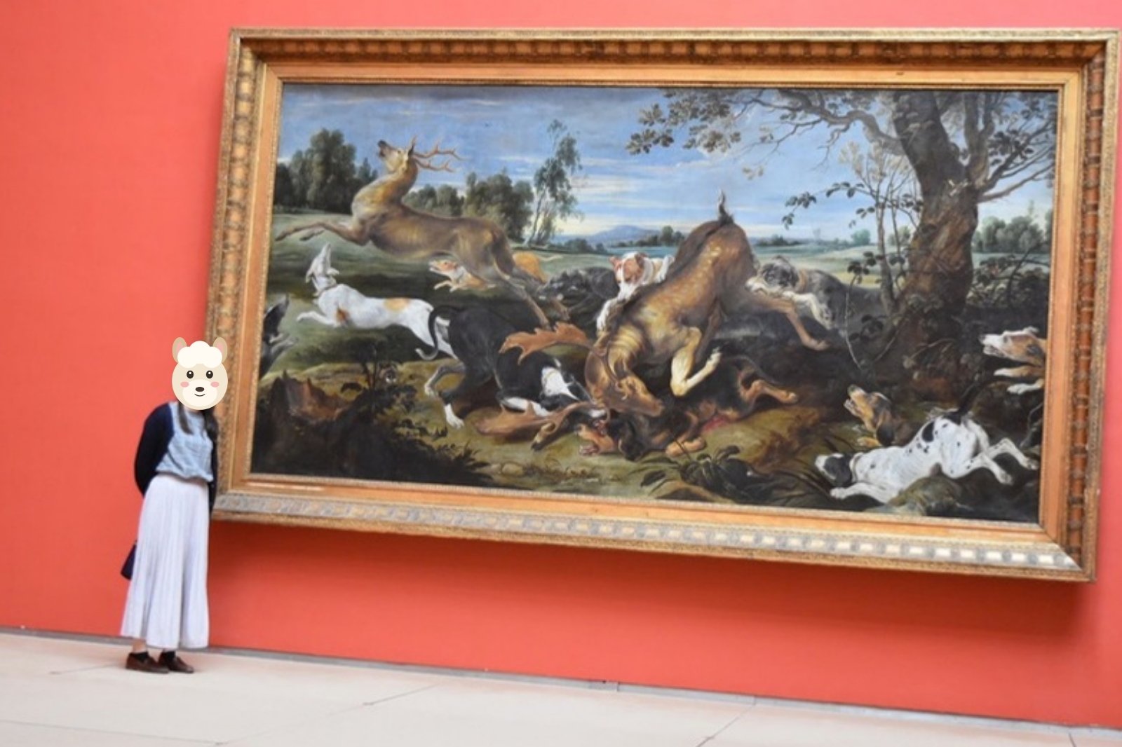 赤い壁の美術館で狩猟画の横に立つ奥さま