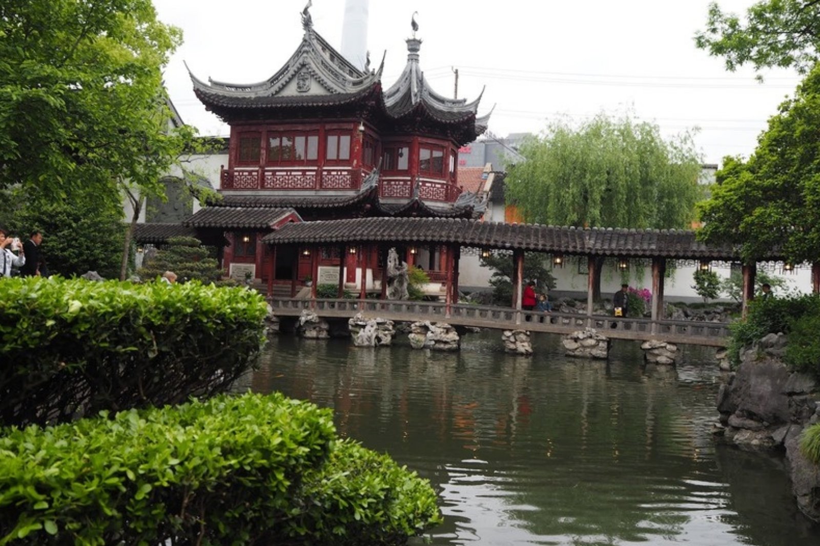 池に面した朱色の楼閣と廃橋のある中国庭園